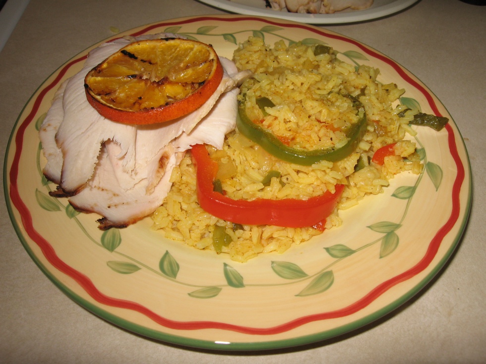 Click to enlarge - Lemon orange chicken, thin sliced with grilled orange garnish, served with skillet rice pilaf.