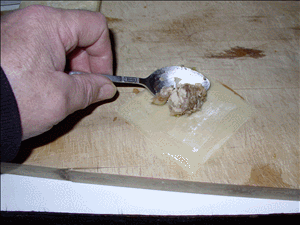 Place a spoonful of filling on the upper half of the wrapper. Fold botom corner up to meet top corner. Gently press out air while sealing sides.  